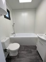 Módulo habitable prefabricado 21 m² (7x3 m) – acabado madera de nogal y baño con bañera